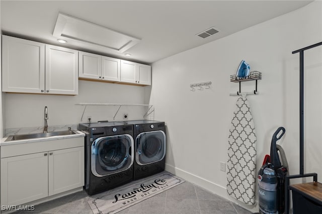 clothes washing area with cabinets, sink, washing machine and dryer, and light tile patterned flooring