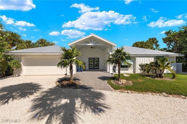 view of front facade with a garage, ceiling fan, french doors, and a front yard