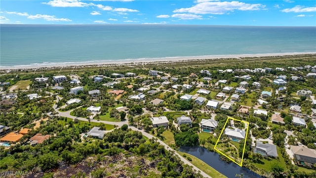 drone / aerial view featuring a water view and a beach view