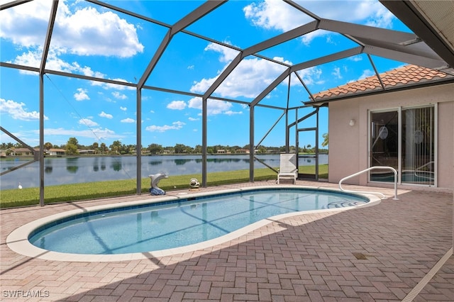 view of swimming pool featuring a patio area, glass enclosure, and a water view