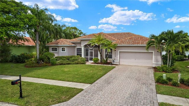 mediterranean / spanish home with a front lawn and a garage