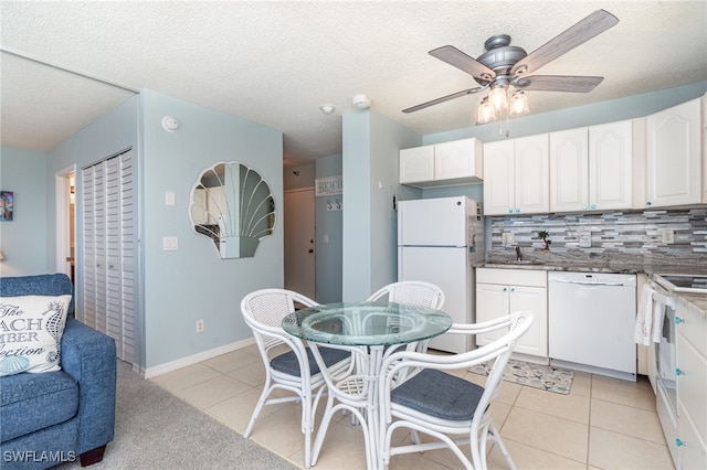 kitchen featuring white cabinetry, tasteful backsplash, white appliances, light tile patterned floors, and ceiling fan