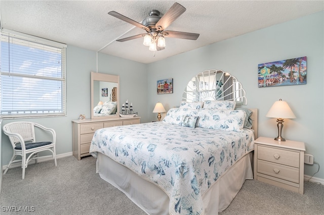 carpeted bedroom featuring ceiling fan and a textured ceiling