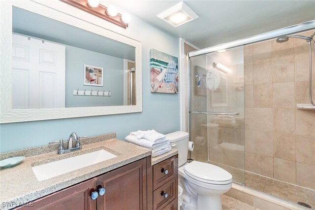 bathroom featuring vanity, toilet, and an enclosed shower