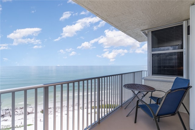 balcony featuring a water view and a beach view