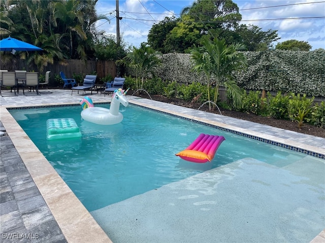 view of swimming pool with pool water feature and a patio area