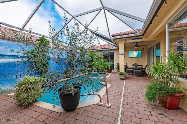 view of patio featuring glass enclosure and ceiling fan