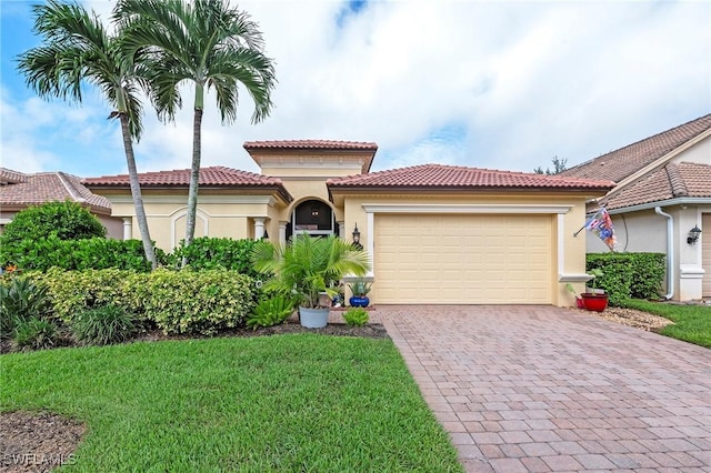 mediterranean / spanish-style home with stucco siding, a tiled roof, decorative driveway, and a garage