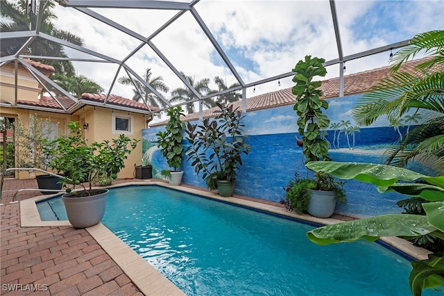 pool featuring glass enclosure and a patio area