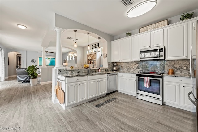 kitchen with appliances with stainless steel finishes, white cabinetry, and decorative columns