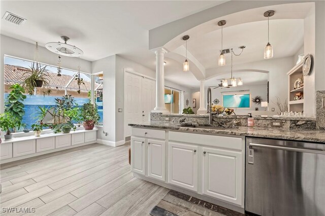 kitchen featuring dishwasher, light hardwood / wood-style flooring, decorative light fixtures, white cabinetry, and decorative columns