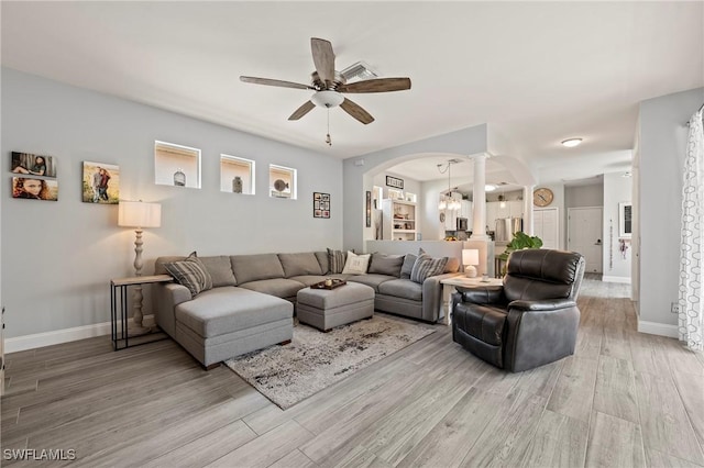 11490 Axis Deer Ln, Fort Myers, FL 33966 - living area with arched walkways, ceiling fan, light wood-style flooring, a chandelier, and ornate columns
