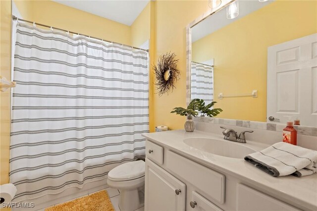 full bathroom with tile patterned floors, toilet, shower / bath combo with shower curtain, and vanity