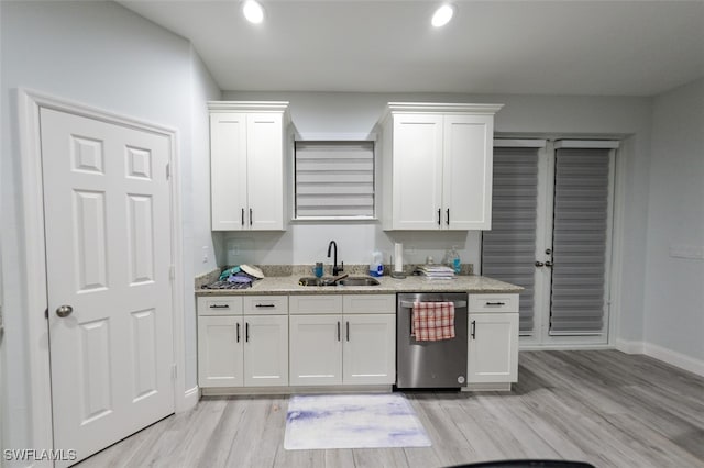 kitchen with light hardwood / wood-style flooring, sink, stainless steel dishwasher, and white cabinets