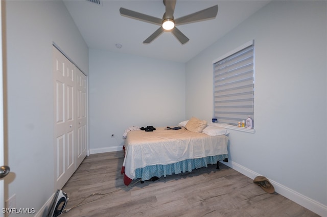 bedroom with a closet, light hardwood / wood-style floors, and ceiling fan