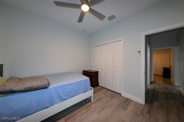 bedroom with a closet, light wood-type flooring, and ceiling fan