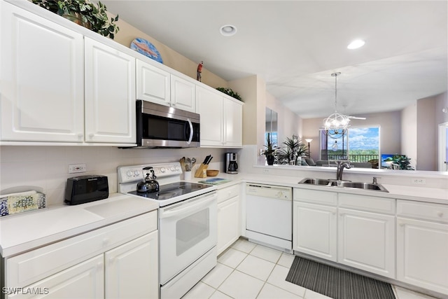 kitchen with white cabinets, sink, white appliances, decorative light fixtures, and a notable chandelier