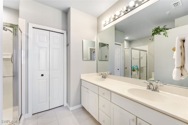 bathroom featuring walk in shower, vanity, toilet, and tile patterned floors