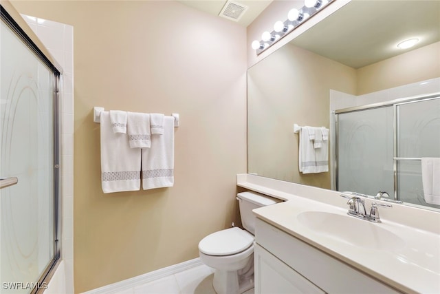 bathroom with vanity, toilet, tile patterned floors, and a shower with shower door