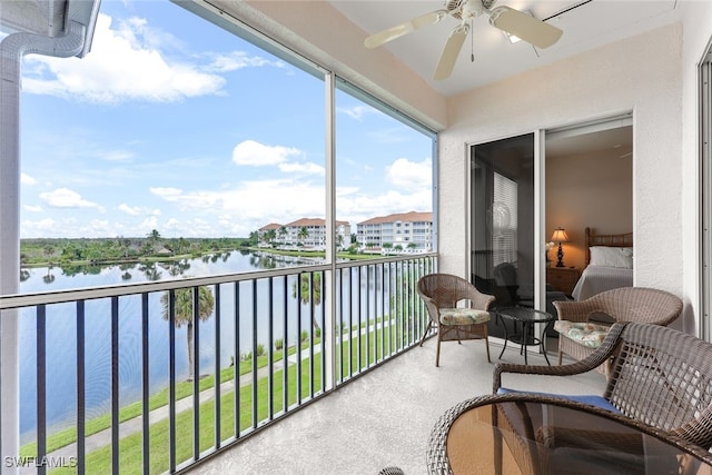 sunroom featuring a water view and ceiling fan