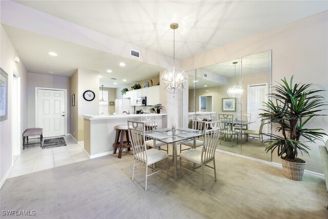 dining room with light colored carpet and a chandelier