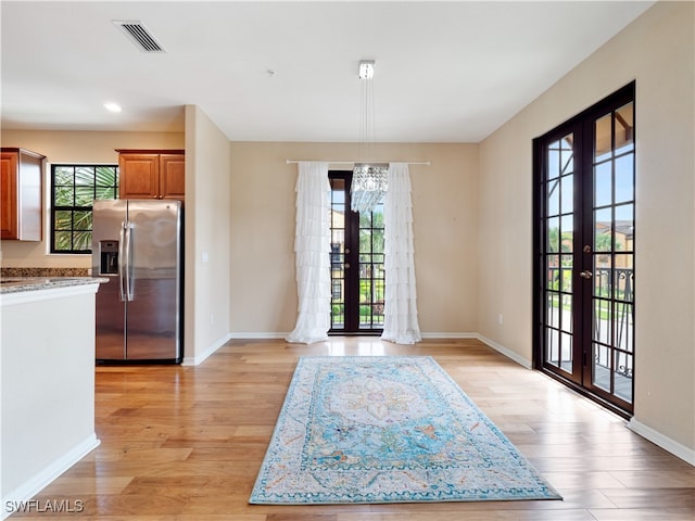 interior space with light wood-type flooring and french doors