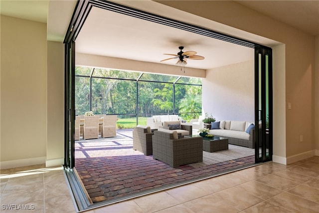 view of patio with ceiling fan, glass enclosure, and an outdoor hangout area