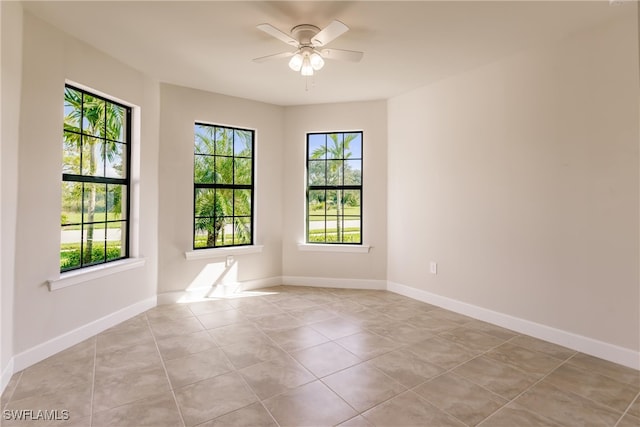 spare room with light tile patterned floors, plenty of natural light, and ceiling fan