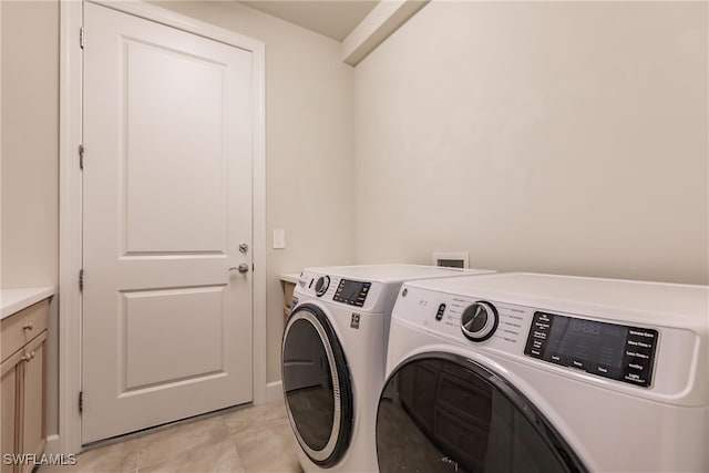 laundry area with independent washer and dryer and cabinets