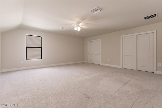 interior space featuring lofted ceiling, light colored carpet, and ceiling fan