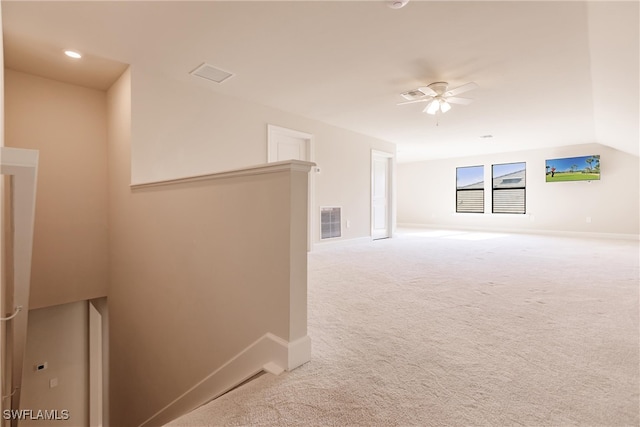 unfurnished room featuring light carpet, vaulted ceiling, and ceiling fan