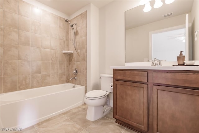 full bathroom featuring vanity, toilet, tiled shower / bath combo, and tile patterned flooring