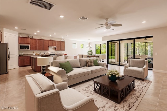 living room with ceiling fan with notable chandelier and light tile patterned floors