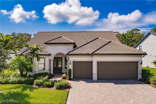 mediterranean / spanish home with a front yard and a garage