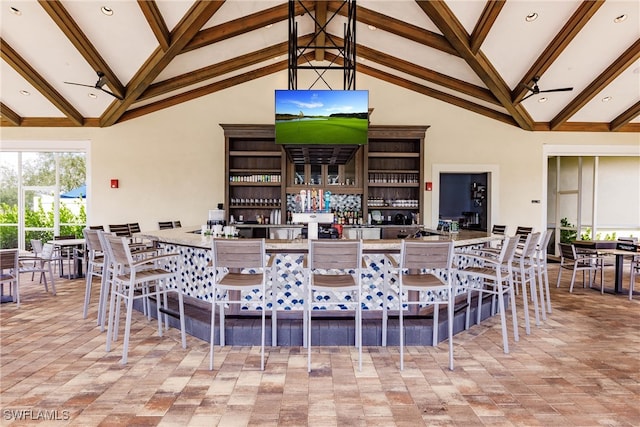 exterior space with beamed ceiling, ceiling fan, high vaulted ceiling, and a breakfast bar area