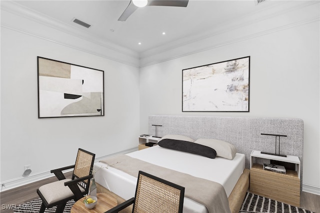 bedroom featuring dark hardwood / wood-style flooring, ceiling fan, and crown molding