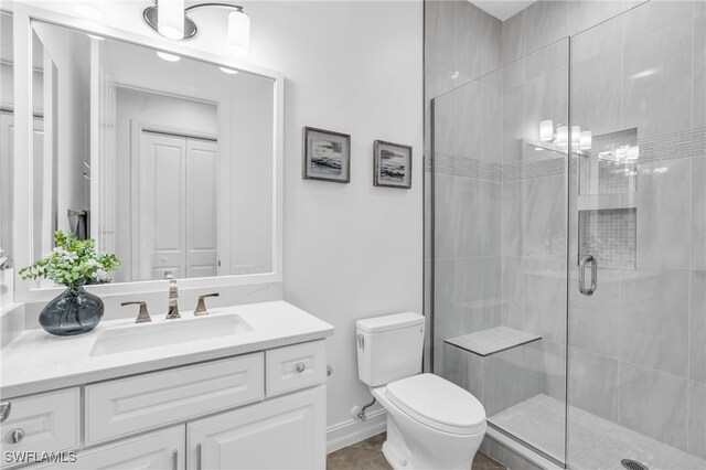 bathroom with vanity, an enclosed shower, and toilet