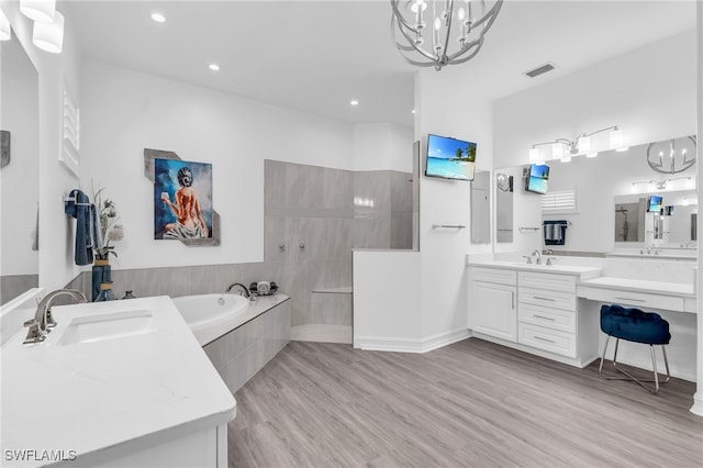 bathroom featuring plus walk in shower, vanity, wood-type flooring, and a notable chandelier