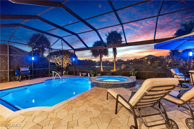 pool at dusk featuring glass enclosure, an in ground hot tub, a patio, and a grill