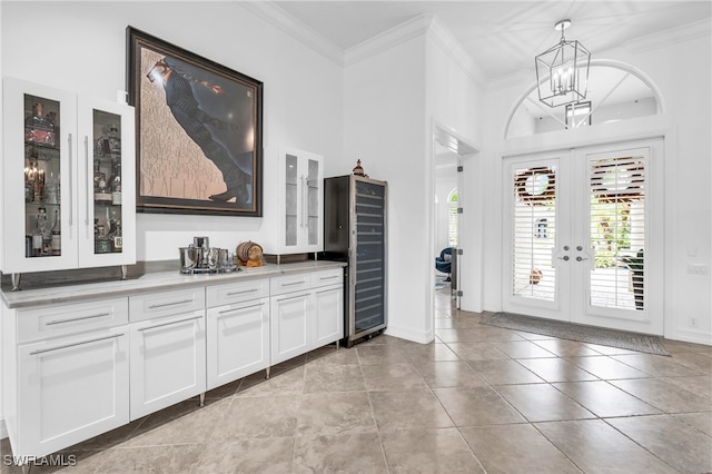 interior space with an inviting chandelier, crown molding, and french doors