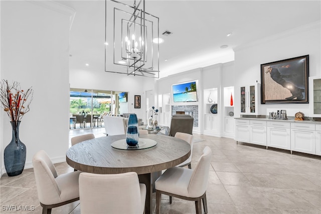 dining space featuring built in shelves, a stone fireplace, and ornamental molding