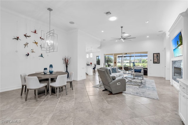 tiled living room featuring ceiling fan with notable chandelier and ornamental molding