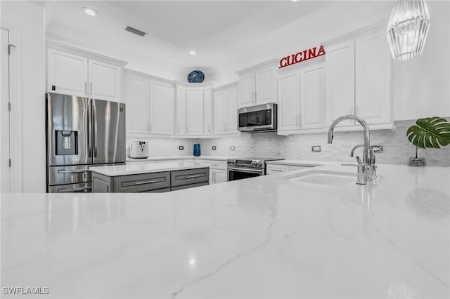 kitchen featuring white cabinets, stainless steel appliances, and light stone counters