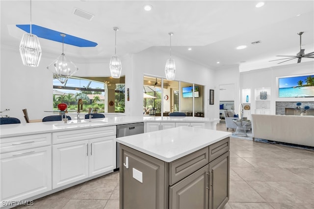 kitchen with white cabinets, decorative light fixtures, sink, and built in shelves