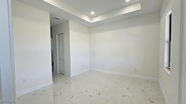 spare room with a tray ceiling