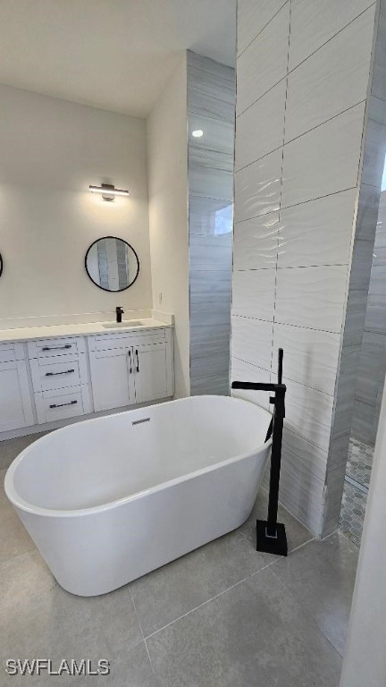 bathroom featuring sink, a bath, tile patterned flooring, and tile walls