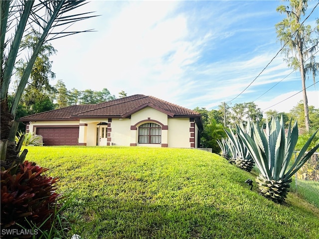 mediterranean / spanish-style house with a garage and a front lawn