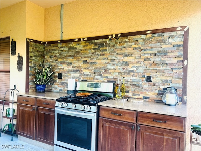 kitchen with light tile patterned floors and stainless steel gas range