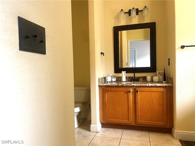 bathroom featuring tile patterned flooring, vanity, and toilet