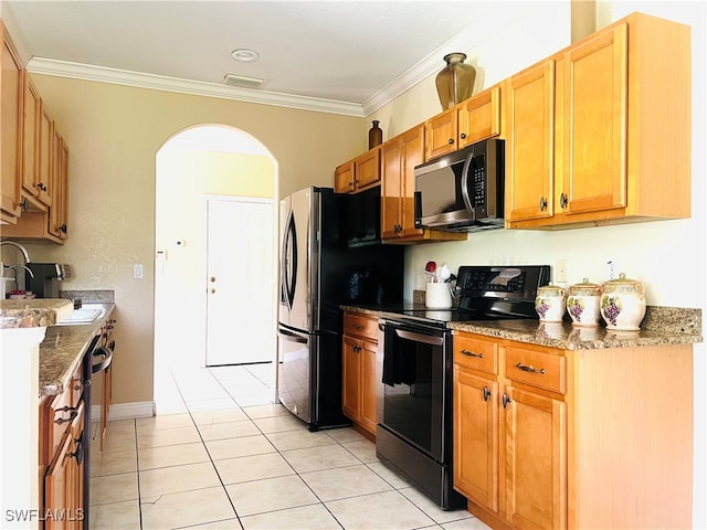 kitchen with appliances with stainless steel finishes, light tile patterned floors, ornamental molding, and sink